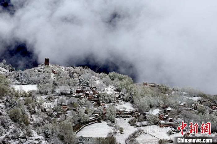 雪后的藏寨和碉樓構(gòu)成美麗的雪景?！〗党鯘衫?攝