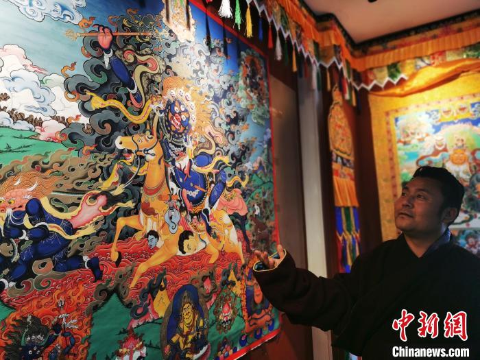 圖為久美尖措展示唐卡作品。　張?zhí)砀?攝