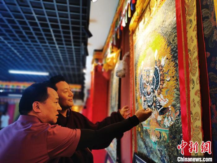 圖為久美尖措展示唐卡作品。　張?zhí)砀?攝