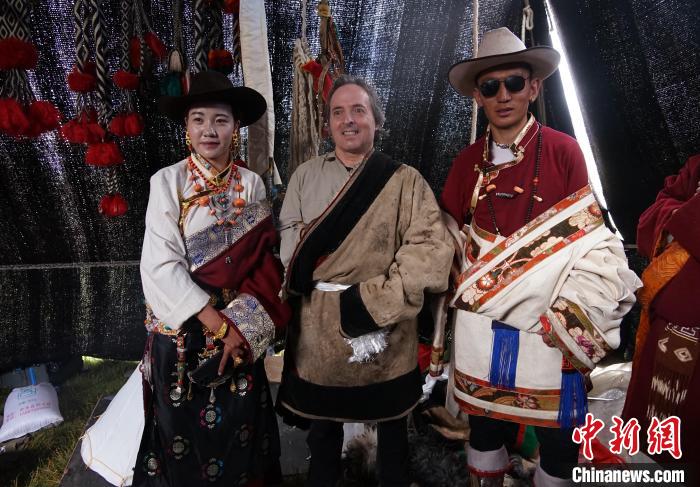圖為一名外籍?dāng)z影師(中)身穿藏服和藏族民眾合影留念?！●R銘言 攝