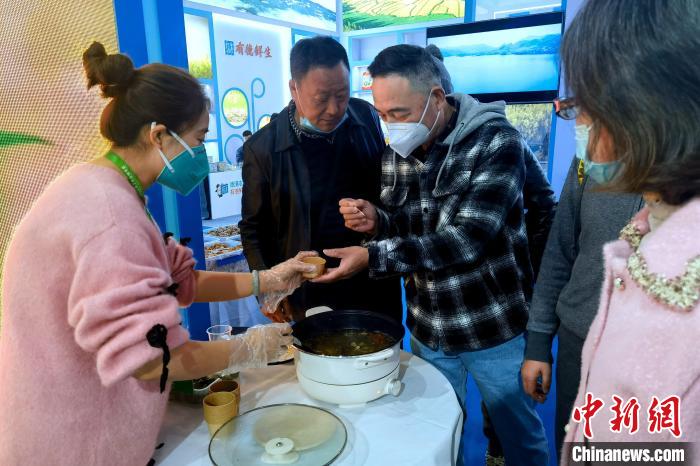 圖為杭州市民品嘗茶卡羊肉。　李雋 攝