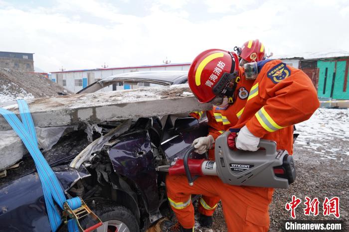 圖為地震實戰(zhàn)拉動現(xiàn)場，參演人員進行車輛破拆?！∮駱湎拦﹫D