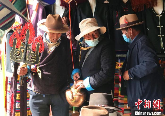 圖為三位藏族老人在集市上聊天交談?！∪轿木?攝