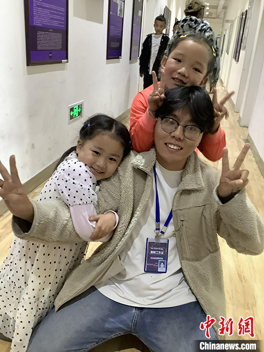 “Z世代”旦真旺加認為，拉薩是一座開放與包容的城市，記憶中的拉薩是彩色的。2021年，旦真旺加從浙江大學漢語言文學專業(yè)畢業(yè)后，他選擇回到拉薩，成為一名漢語文實習助教。圖為8月4日，旦真旺加在課間陪學生玩耍。 <a target='_blank' ><p  align=