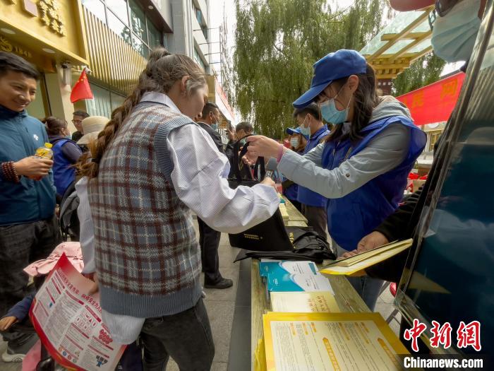 圖為志愿者為市民發(fā)放網(wǎng)絡(luò)安全宣傳手冊(cè)?！≈x牧 攝