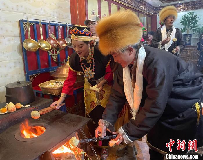 圖為人們?cè)诨鹕峡竟?jié)日美食“結(jié)達(dá)”?！∪轿木?攝