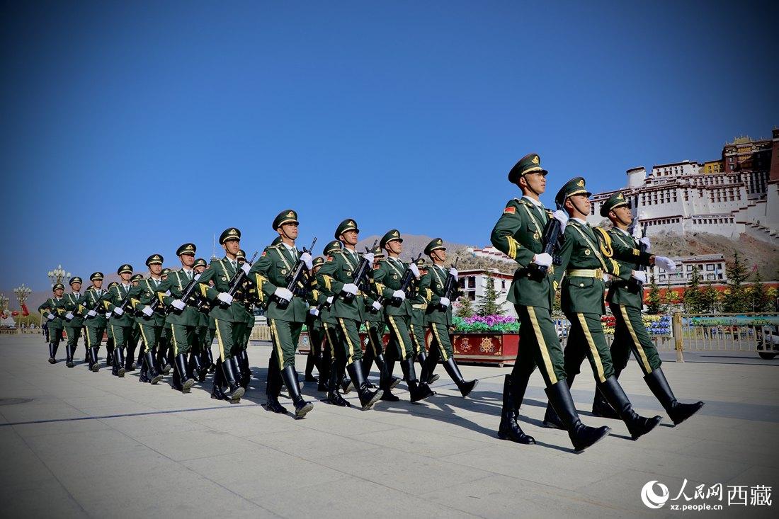 國旗護(hù)衛(wèi)隊隊員緊握鋼槍，踏著威武雄壯的步伐，走向國旗臺。人民網(wǎng) 次仁羅布攝