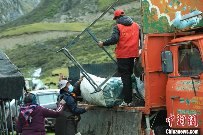 圖為工作人員幫助牧民們卸家具?！÷蹇?攝