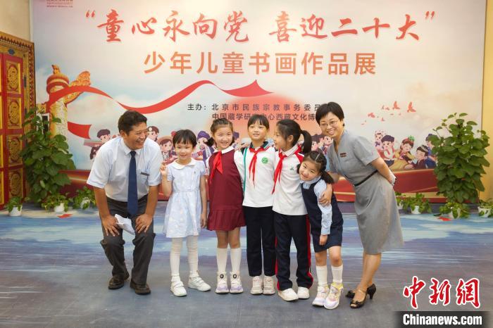 圖為與會(huì)嘉賓與入選畫作的“小作者”們?cè)谡褂[上合影?！≈袊貙W(xué)研究中心供圖