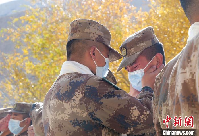 圖為什布奇邊防連退伍老兵與戰(zhàn)友相擁而泣，依依惜別?！⌒觳?攝