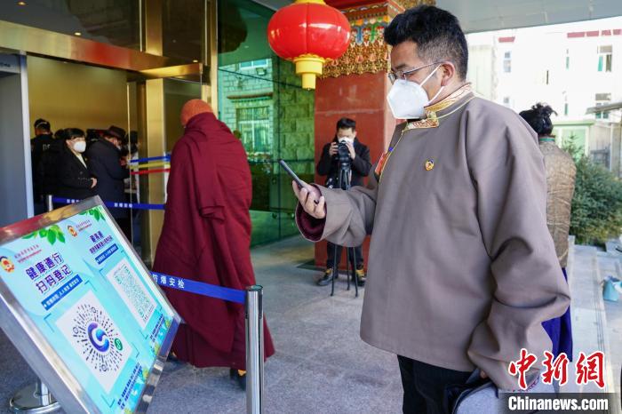圖為政協(xié)委員掃場所碼進(jìn)入會場?！〗w波 攝