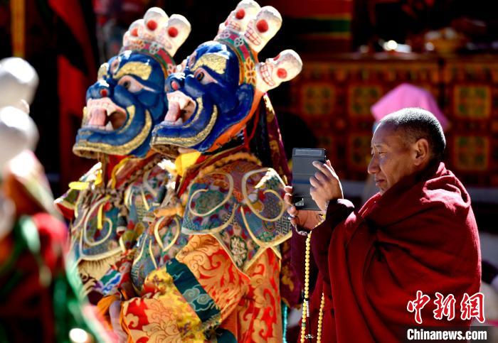 2月19日，正在拍攝跳神活動(dòng)的僧人?！±盍?攝