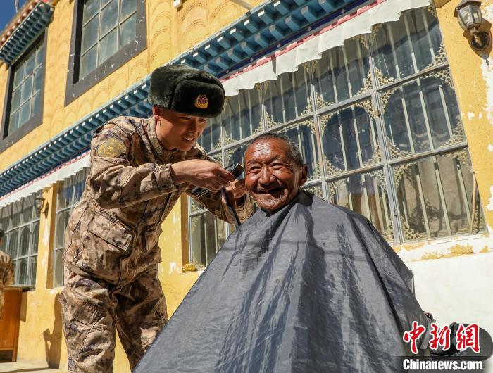 圖為阿里軍分區(qū)某邊防團官兵為駐地群眾理發(fā)迎藏歷新年?！〉┰鰝愔?攝