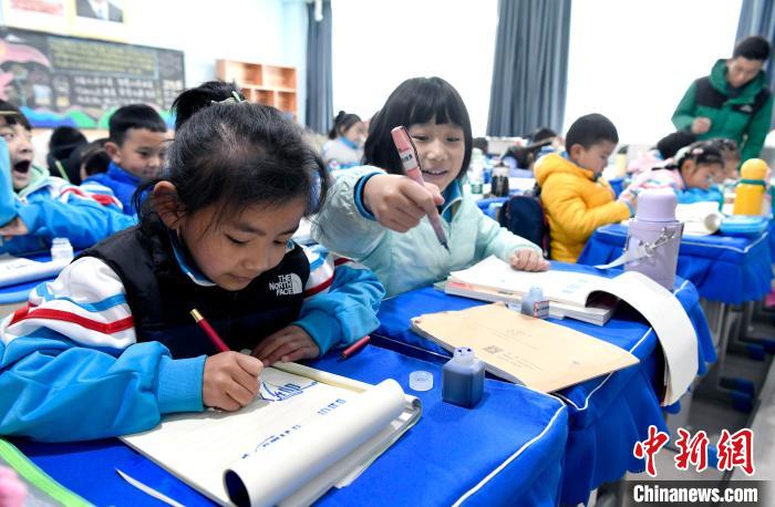3月14日，西藏拉薩市第一小學一年級六班學生白瑪朗珍(圖左)在藏語文課上書寫藏文?！±盍?攝