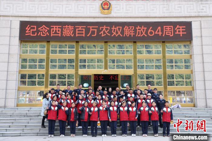 圖為亞?wèn)|邊檢站民警代表與駐地小學(xué)師生代表合影留念。　胡利媛 攝