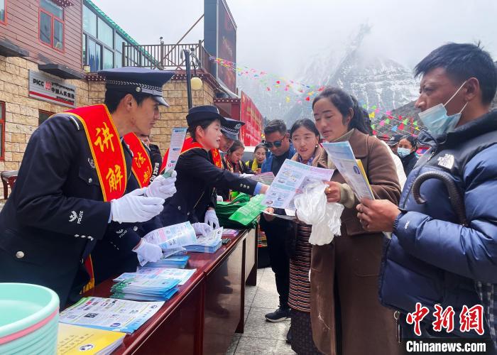 圖為山南玉麥邊境派出所民警為轄區(qū)群眾發(fā)放法律知識宣傳單?！＄婗?　攝