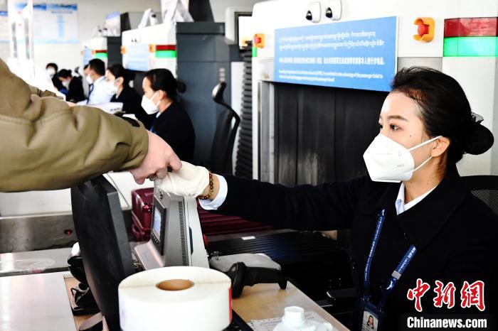 圖為機場工作人員為旅客辦理行李托運?！≈芎?攝