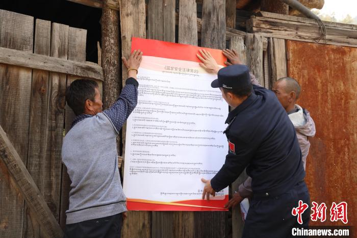 圖為亞東邊檢站民警與駐地邊民群眾共同張貼國(guó)家安全知識(shí)教育海報(bào)。　亞東邊檢站 供圖
