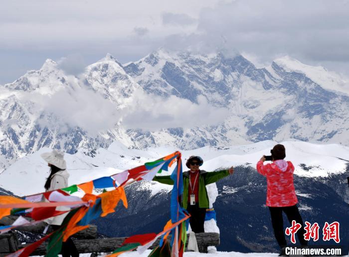 圖為5月14日，西藏林芝色季拉山觀景臺(tái)，游客與南迦巴瓦峰合影。　李林 攝