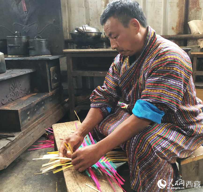 門巴族漢子愛明正在編織藤竹品。