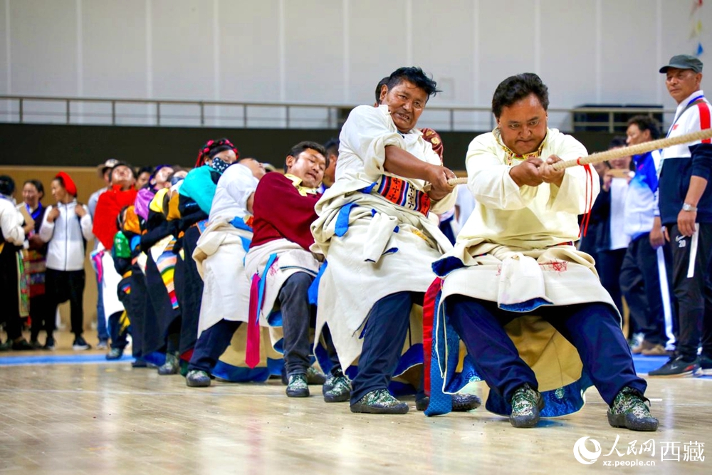 身著民族服裝的農(nóng)牧民選手在拔河比賽現(xiàn)場。