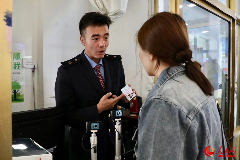 車站工作人員向旅客解答疑問。人民網(wǎng)記者 次仁羅布攝